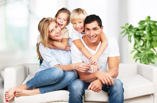 Young  family at home smiling at camera