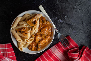 Penne pasta in pork sauce with mushroom.