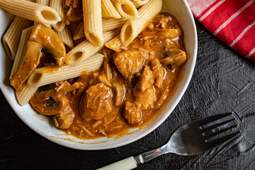 Penne pasta in pork sauce with mushroom.