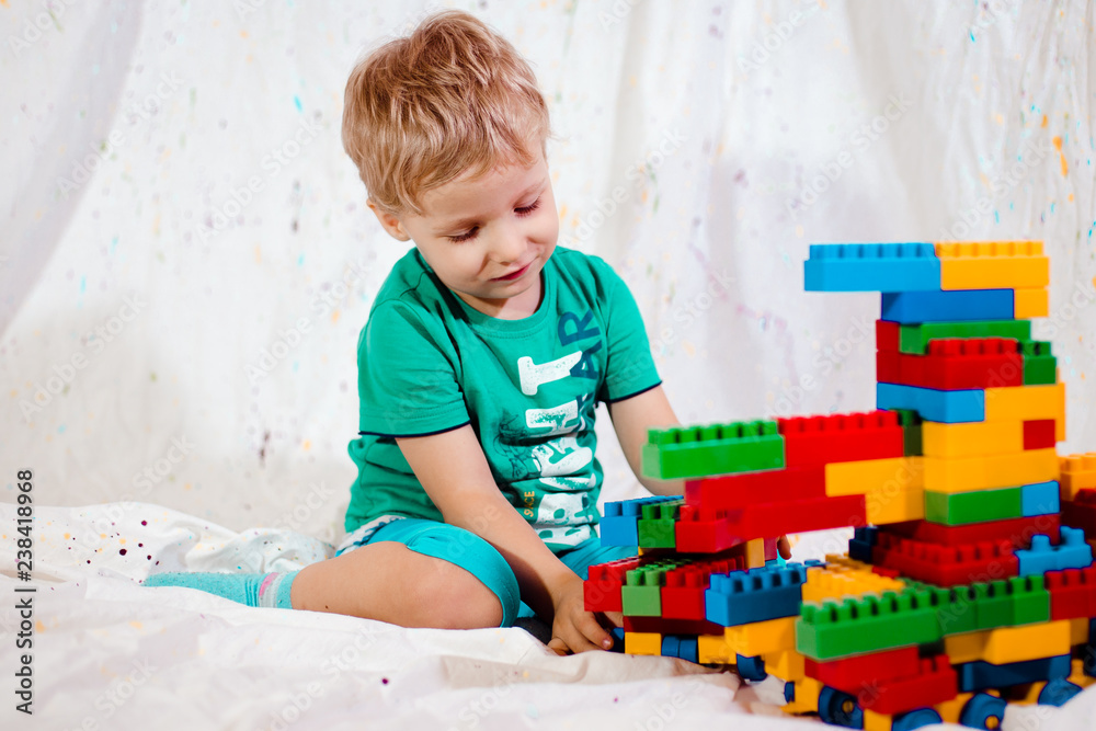 Wall mural small child learns to fold constructor