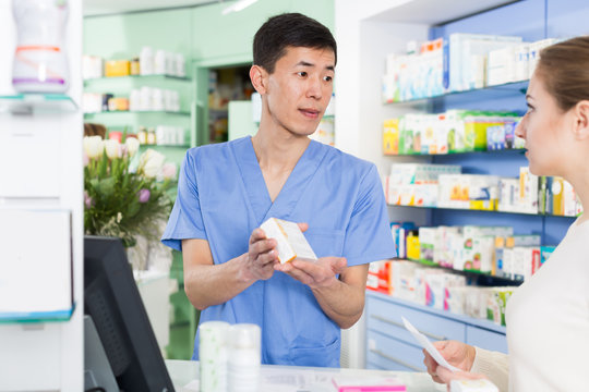 Glad woman is asking pharmacist about medicines