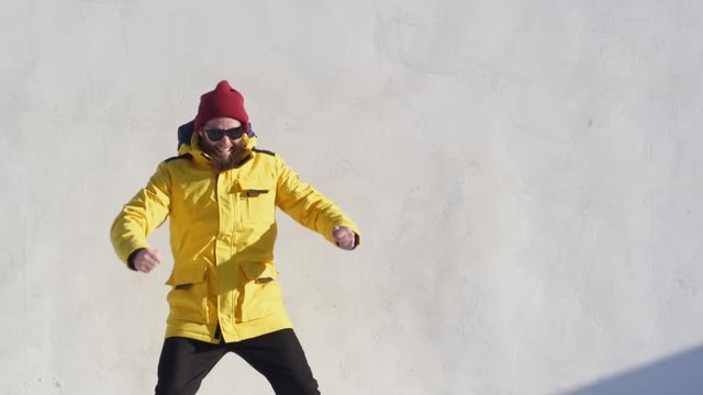 Hipster man with beard smiling and expressing emotions. He is wearing yellow jacket
