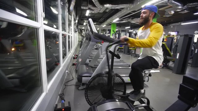 hipster man in a gym cycling