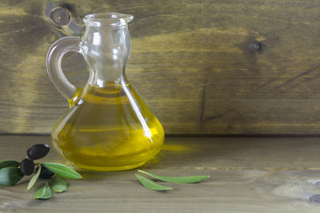 Olive oil and olive branch on the wooden table