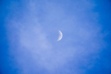 Clearly beautiful blue sky with white half moon.