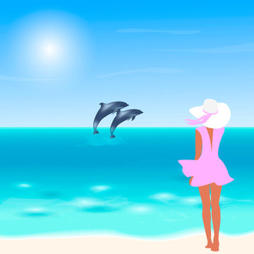 The girl watches the dolphins in the sea. A girl in a pink dress walks along the beach. Sea landscape.