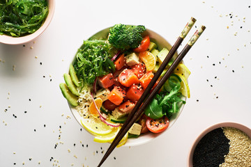 poke bowl with salmon, avocado, cucumber, arugula, broccoli, rice, carrot and sweet onions with...