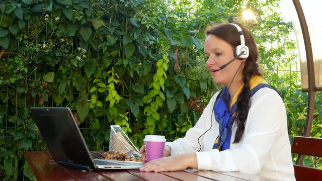 business woman in a cafe talking through a headset