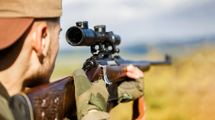 Hunter is aiming. Shooter sighting in the target. Hunter man. Hunting period. Male with a gun. Close up. Hunter with hunting gun and hunting form to hunt. The man is on the hunt. Hunt hunting rifle.
