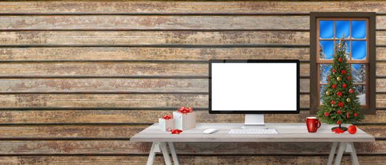 Computer display mockup and copy space beside. Christmas tree and decorations on white wooden desk.