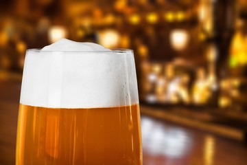 Glass of light beer on a dark pub