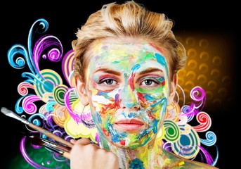 Young beautiful woman with painted  face and paintbrushes