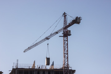 Fototapeta na wymiar Construction site with yellow crane on blue sky background. Construction, construction work, lifting heavy loads up