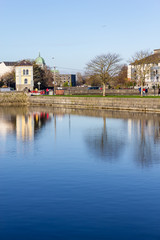 Fototapeta na wymiar Building reflection in Corrib river pier