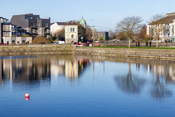 Building reflection in Corrib river pier