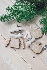 Wooden christmas decoration - christmas mittens, hat, sweater on a white wooden background with christmas tree