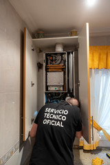 reparador de calderas perteneciente a un servicio técnico oficial realizando una reparación o una...