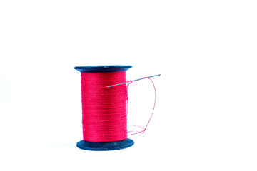 Spool of Red Thread with Needle on White Background