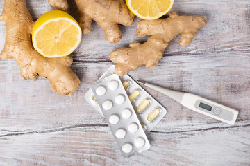 Ginger tea ingredients concept, Healthy concept. Tea, lemon, thermometer, ginger and tablets on a white background. Flat lay. Top view