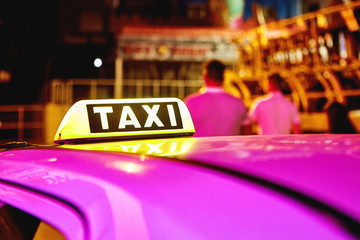 taxi car roof sign at night. taxi car on the street at night. selective focused image toned picture