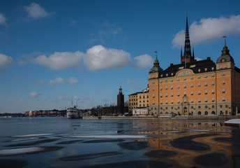 Naklejka premium Winter view of Stockholm a frozen lake Mälaren and snow over the Town City Hall and the island Riddarholmen 