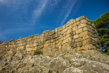 stone wall construction building landmark object ancient Roman Empire heritage on rock environment landscape place, clear weather, empty vivid blue sky, sightseeing tourist concept  