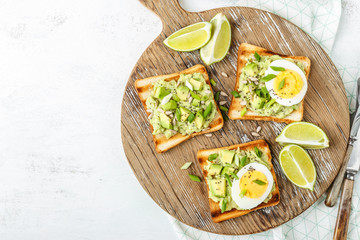 avocado toasts, healthy snack of grilled bread with guacamole slices avocado, boiled eggs, chia seeds and green onions