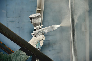 A man produces powder paint metal products.