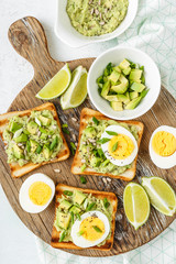 avocado toasts, healthy snack of grilled bread with guacamole slices avocado, boiled eggs, chia seeds and green onions