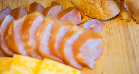 juicy chicken fillet on a wooden board, boneless skinless, with pieces of marble cheese and bread, close-up