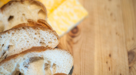 juicy chicken fillet on a wooden board, boneless skinless, with pieces of marble cheese and bread, close-up