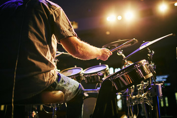 man from behind playing drums at concert