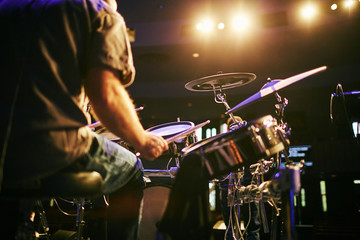 man from behind playing drums at concert