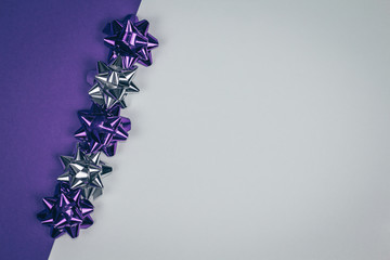 Shining violet and silver Christmas ornament lined diagonally on violet and white background.