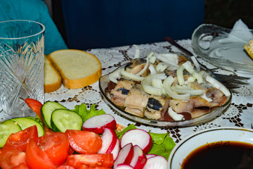 Marinated herring with onion cut into pieces in a plate poured with sunflower oil.