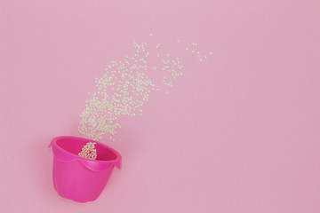 Pink baking cup on the pink background sprinkled with sesame.