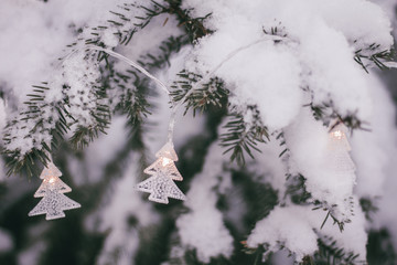Christmas garland on the snowy fir tree.