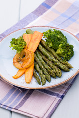 Fried asparagus with broccoli and lemon and carrot.