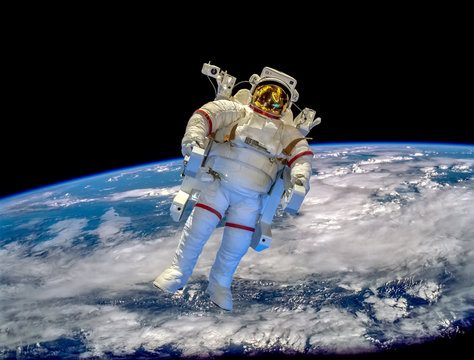 Astronaut at spacewalk. Cosmic art, science fiction wallpaper. Beauty of deep space. Billions of galaxies in the universe. “Elements of this image furnished by NASA”