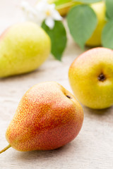 Fresh pears with leaves in a on wooden background.