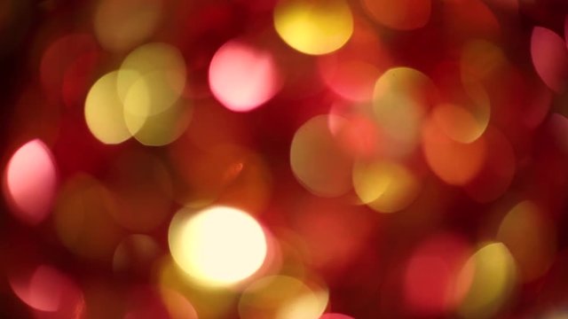 Defocused colourful bokeh abstract noel shiny sparkling lights background of golden and red colors isoated on black. Real time full hd video footage.