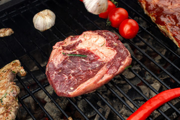 Beef steaks on the grill with flames.