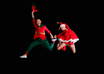 Christmas time, childhood, fairy tale. A young girl wearing a Santa's costume and boy wearing elf...