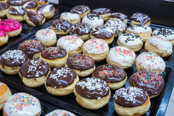 assorted donuts with chocolate frosted, pink glazed and sprinkles donuts