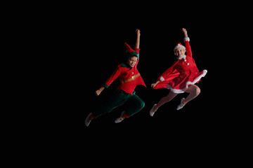 Christmas time, childhood, fairy tale. Cheerful kids - A young girl wearing a Santa's costume and...
