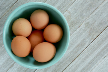 Brown eggs in turquoise bowl