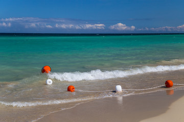 Safety float line on a soft wave in a white sand beach