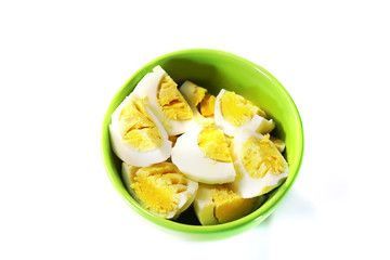 boiled chicken eggs in a green bowl. White background.