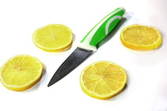 sliced lemon and fruit knife on a white background.