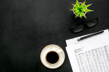 Breakfast in office with coffee on the work desk with documents and glasses on black background top view space for text